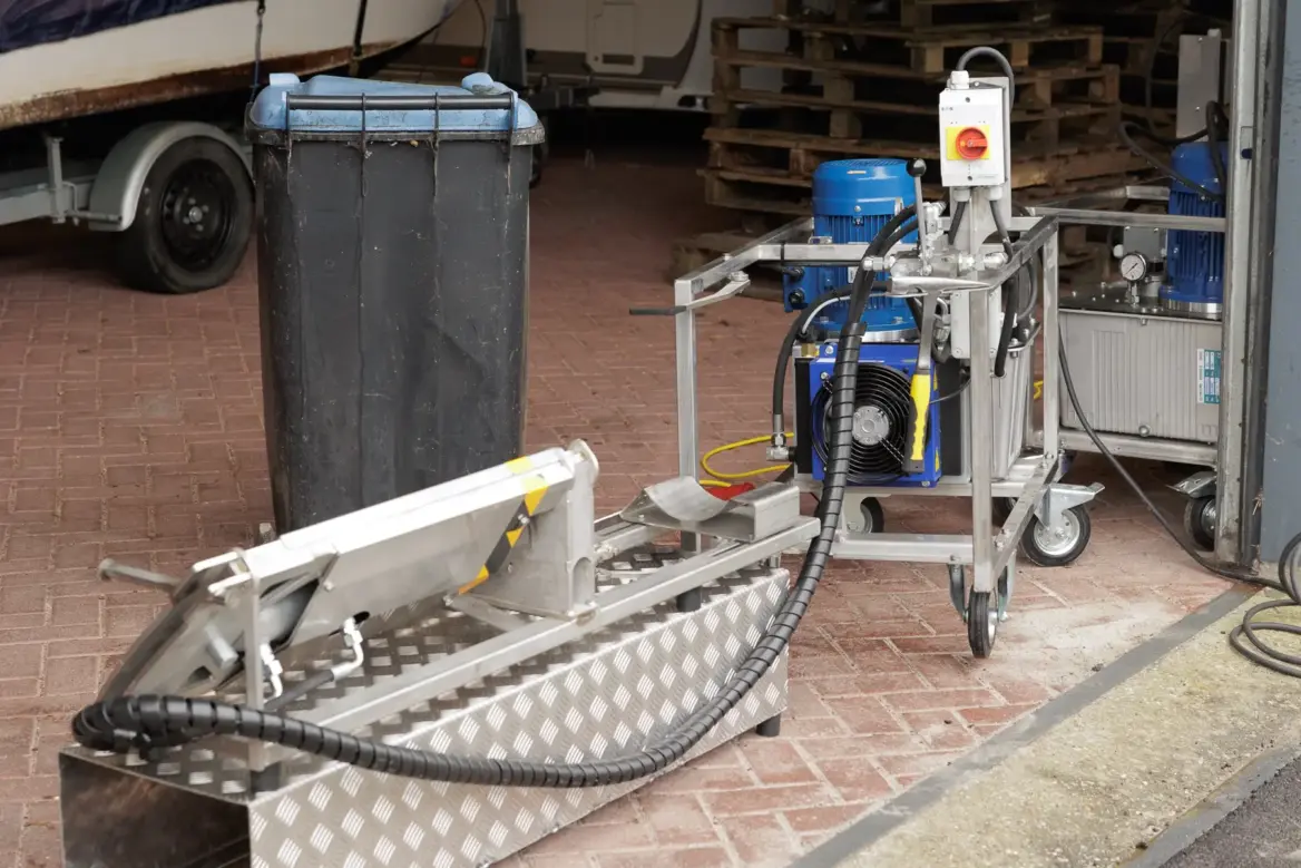 Wielstripmachine met aggregaat en afvalcontainer